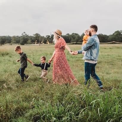 a group of people holding hands and walking in a field