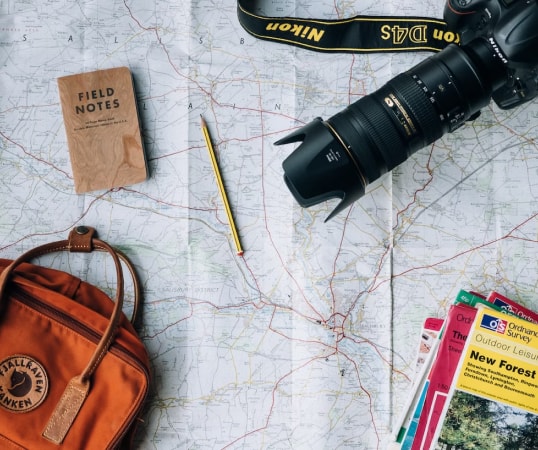 a camera and a backpack on a map