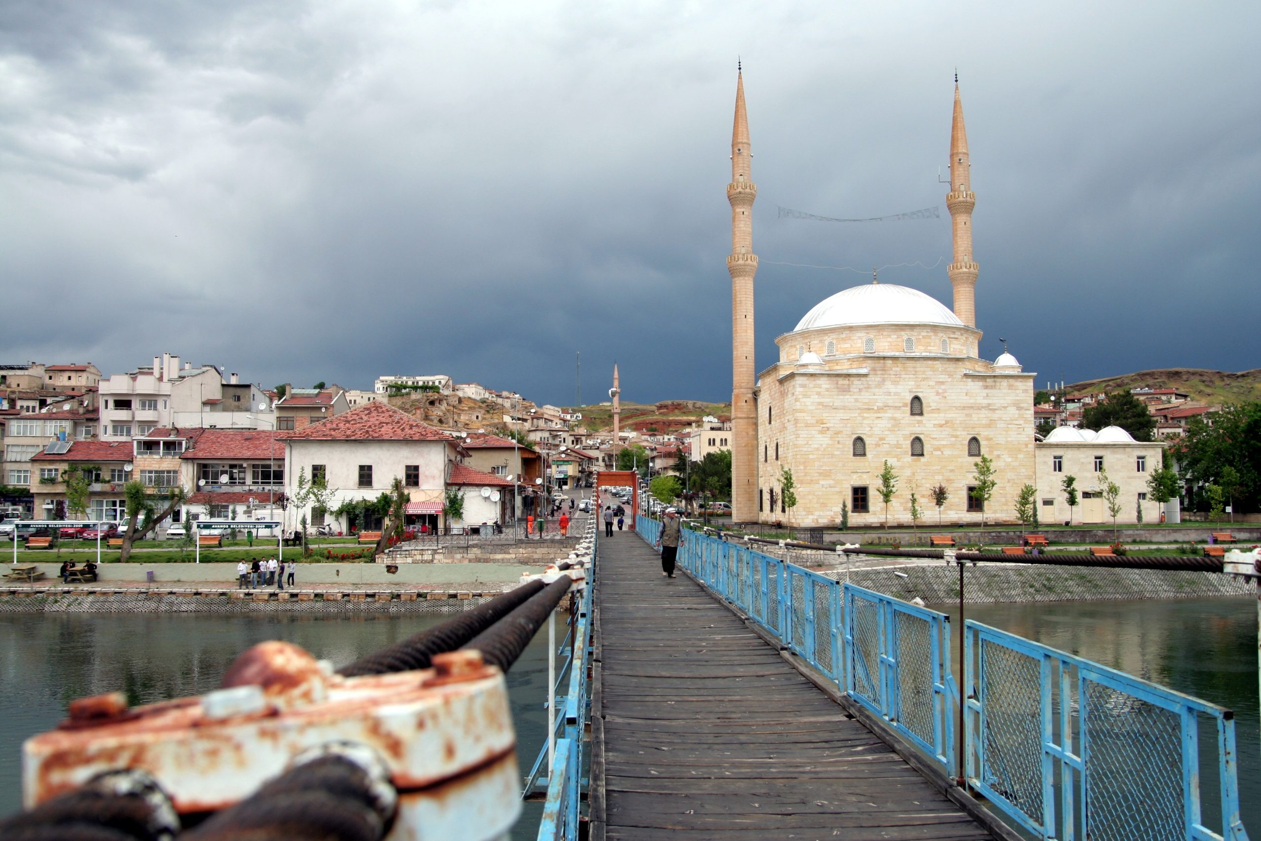 a bridge with a body of water and a building in the background