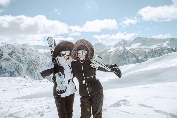 two people in ski gear on a snowy mountain