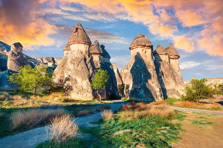 a group of tall rocks with a blue sky and clouds