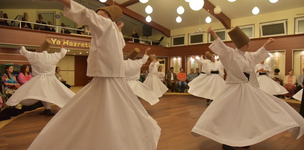 a group of people wearing white robes and dancing